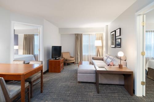 a hotel room with a couch and a table at Residence Inn New Bedford Dartmouth in North Dartmouth