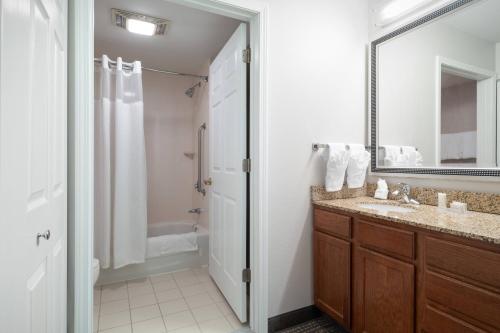 uma casa de banho com um lavatório, um chuveiro e um espelho. em Residence Inn New Bedford Dartmouth em North Dartmouth