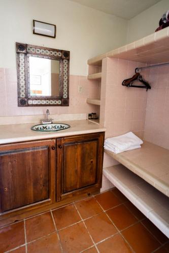 a bathroom with a sink and a mirror and shelves at Hotel Rancho Buenavista in Los Barriles