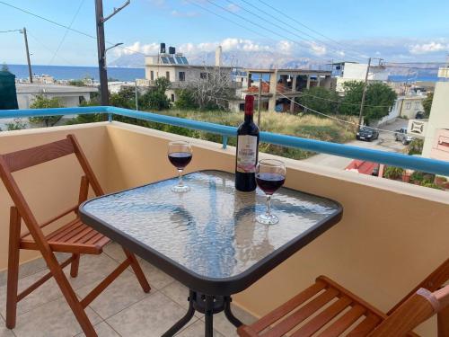 einen Tisch mit zwei Gläsern Wein auf dem Balkon in der Unterkunft Kisamos Nice Apartment 3 in Kissamos