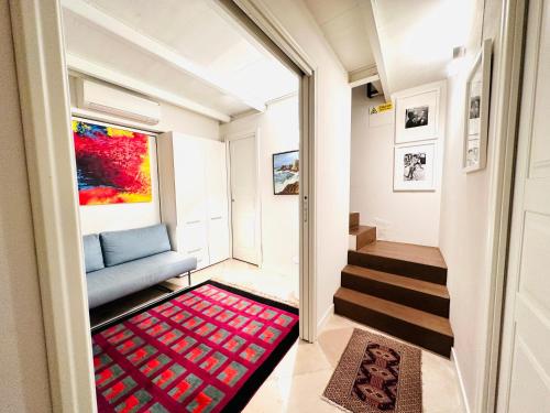 ein Wohnzimmer mit einem blauen Sofa und einem roten Teppich in der Unterkunft ComeCasa Entire House Port View - Two Bedrooms in Saint-Tropez