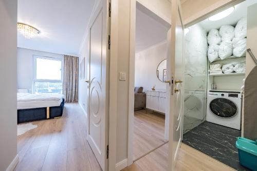 a room with a door leading to a bedroom with a washer and dryer at Nowa Letnica Apartament in Gdańsk