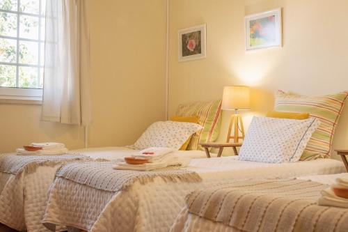 1 dormitorio con 2 camas y ventana en AmendoeirasHouse, en Abrantes