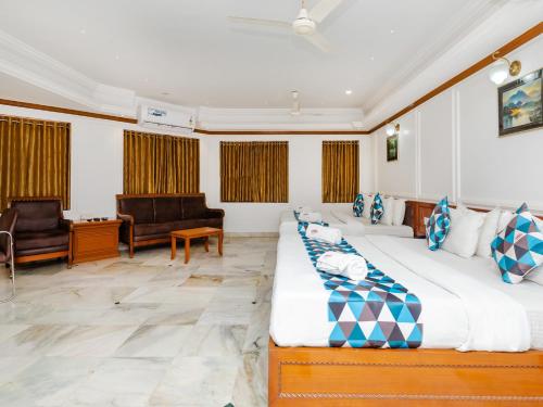 a bedroom with two beds and a living room at Hotel Galaxy Opp Surat Railway Station in Surat