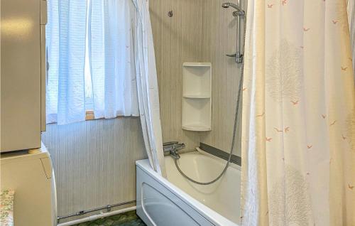 ein Bad mit einer Badewanne und einer Dusche mit einem Waschbecken in der Unterkunft 3 Bedroom Nice Home In Valldal in Valldal