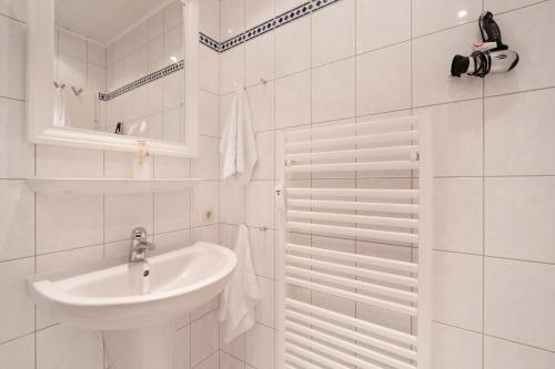 y baño blanco con lavabo y ducha. en Villa Hoffnung Strandoase Kellenhusen, en Kellenhusen