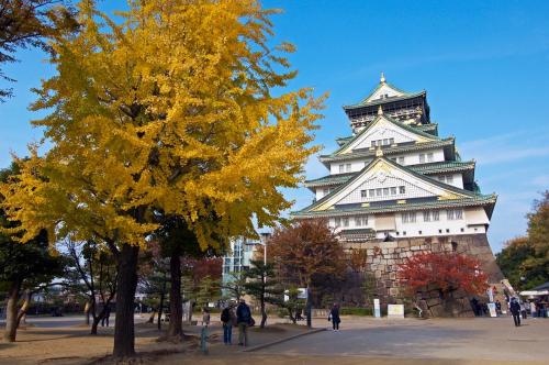 a large building with a tree in front of it at Floral Hotel East Shinsaibashi in Osaka