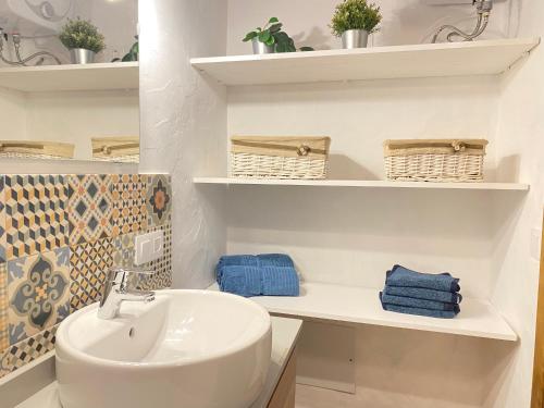 łazienka z umywalką i półkami z ręcznikami w obiekcie Mardelava w mieście Tinajo