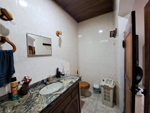 a bathroom with a sink and a toilet at Paradisíaco, piscina e churrasqueira em Guapimirim in Barreira