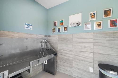La salle de bains est pourvue de toilettes et de photos murales. dans l'établissement Elegant 3BR/2BA Condo Near Beaches & Attractions, à Melbourne