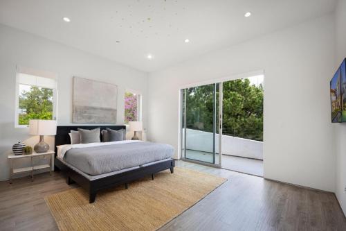 a bedroom with a bed and large windows at Alfred Villa in Los Angeles