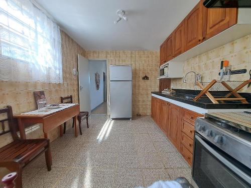 a kitchen with a refrigerator and a table in it at Lindo Apto com VAGA no melhor Ilha do Governador in Rio de Janeiro