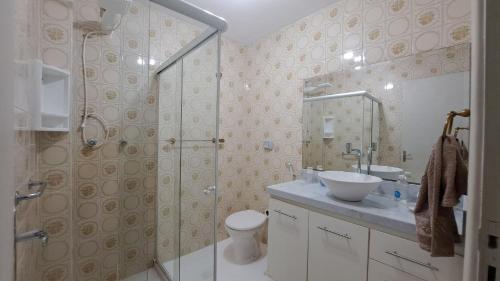 y baño con ducha, aseo y lavamanos. en Lindo Apto com VAGA no melhor da Ilha do Gov, en Río de Janeiro