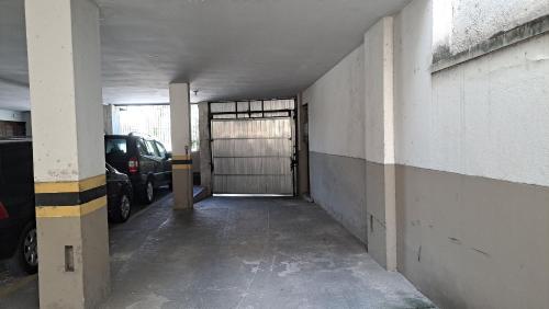 a parking garage with a garage door with cars in it at Lindo Apto com VAGA no melhor Ilha do Governador in Rio de Janeiro