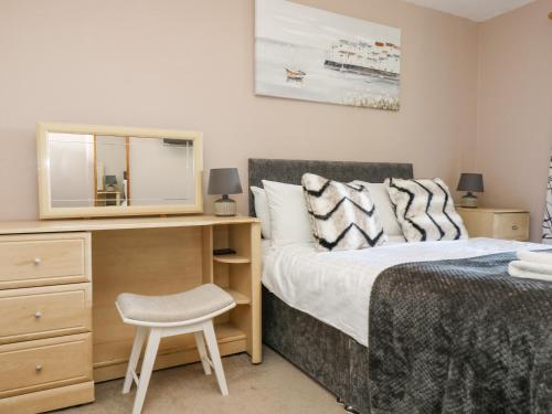 1 dormitorio con cama, escritorio y silla en Valley Lodge 61, en Gunnislake