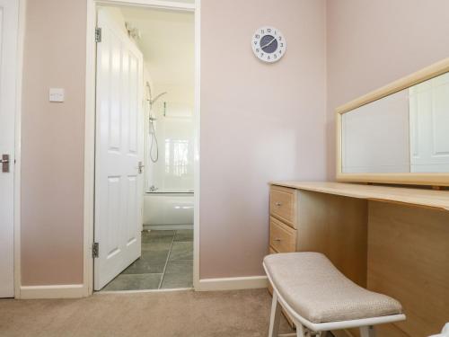 a bathroom with a desk and a chair and a mirror at Valley Lodge 61 in Gunnislake
