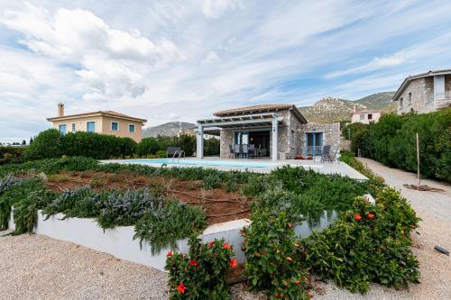 a house with a garden and a swimming pool at Costa Bianca Villas in Koilás