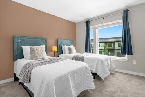 two beds in a room with a window at 4 Bedrooms 35 Bathrooms Le Reve 4423 Lr in Kissimmee