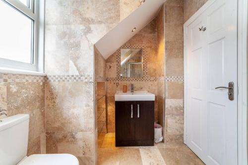 2 Bedroom Duplex Apartment في لندن: حمام مع حوض ومرحاض