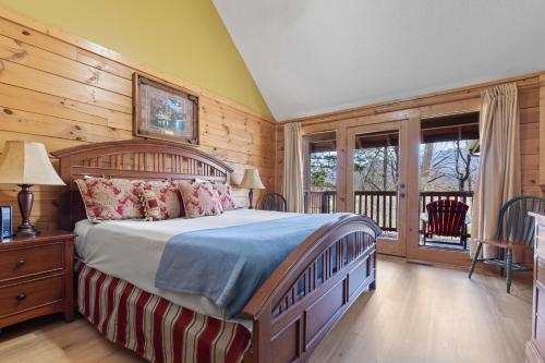 a bedroom with a large bed and a balcony at Above the Clouds, 4 Bedrooms, Pool Access, Private, Gaming, Sleeps 16 in Gatlinburg