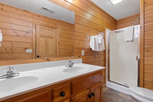 a bathroom with a white sink and a shower at Above the Clouds, 4 Bedrooms, Pool Access, Private, Gaming, Sleeps 16 in Gatlinburg