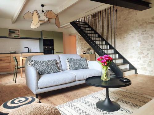 a living room with a couch and a table with flowers at Uzès médiévale l'écrin d'Amalia in Uzès