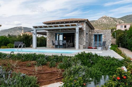 a stone house with a pool and a pergola at Costa Bianca Villas in Koilás