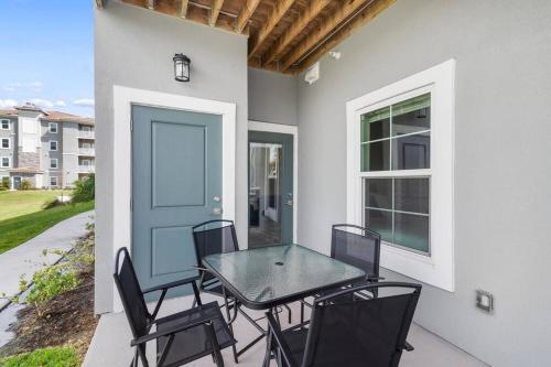 a table and chairs on a patio with a blue door at Luxury 3 Bedroom/2 Bathroom Condo in Melbourne FL with Pool, Gym and Laundry in Melbourne