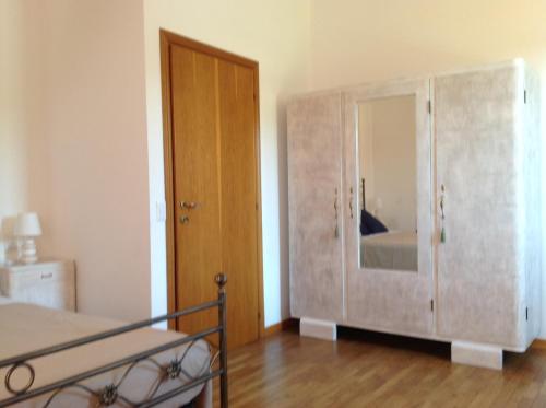 a bedroom with a wooden door and a mirror at Appartamento La Betulla in San Giovanni in Marignano