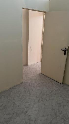 an empty room with two white doors and a tile floor at comfortable homeroom for upto 2 persons in Sharjah