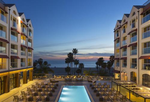 a view of a hotel with a pool and chairs at Regent Santa Monica Beach in Los Angeles