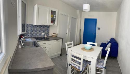a kitchen with a sink and a table with chairs at Blu Rooms Marettimo in Marettimo