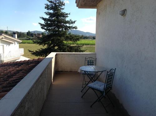 two chairs and a table on a balcony with a tree at Appartamento La Betulla in San Giovanni in Marignano