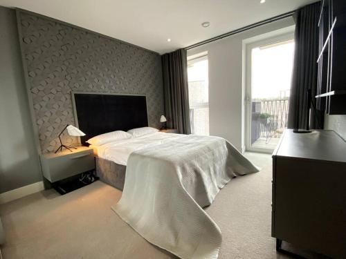 ein Schlafzimmer mit einem Bett und einem großen Fenster in der Unterkunft Club White London Bridge One Bedroom Apartment in London