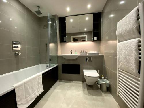 ein Badezimmer mit einem WC, einem Waschbecken und einer Badewanne in der Unterkunft Club White London Bridge One Bedroom Apartment in London