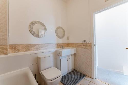 a bathroom with a toilet and a sink and a tub at Up to 4 people, Room In a Share house next to London Bridge in London