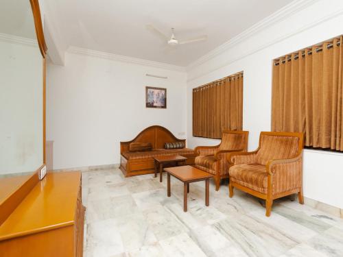 a living room with chairs and a piano at Hotel Galaxy Opp Surat Railway Station in Surat