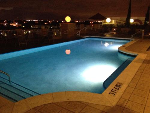 a swimming pool at night on a rooftop at Dadeland Towers by Miami Vacations in South Miami