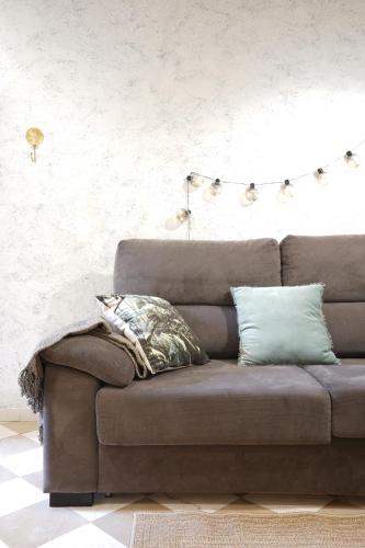 Sofá marrón en la sala de estar en ADANAR-Las Columnas, en Granada