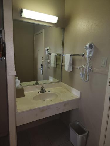 a bathroom with a sink and a large mirror at Colonial Inn Monahans TX in Monahans