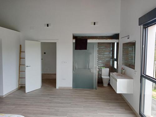 a white bathroom with a toilet and a sink at Casa pipete in Siero