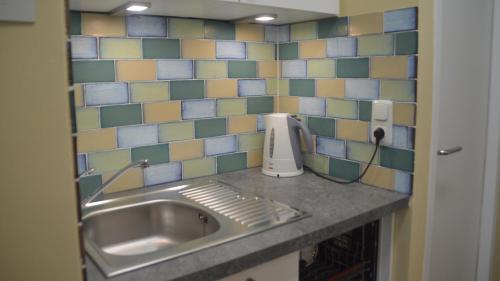 a kitchen counter with a sink and a tiled wall at Seeluft 33 in Wangerooge