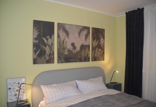 1 dormitorio con 1 cama con 3 cuadros en la pared en Seeluft 33 en Wangerooge