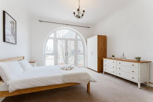 a bedroom with a bed and a dresser and a window at Spacious Ensuite Room Near Top Tourist Attractions in London