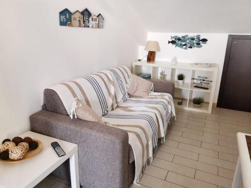 サンタ・マリア・デル・フォカッロにあるEsperienza Luxury fronte mare con piscinaのリビングルーム(ソファ、毛布付)