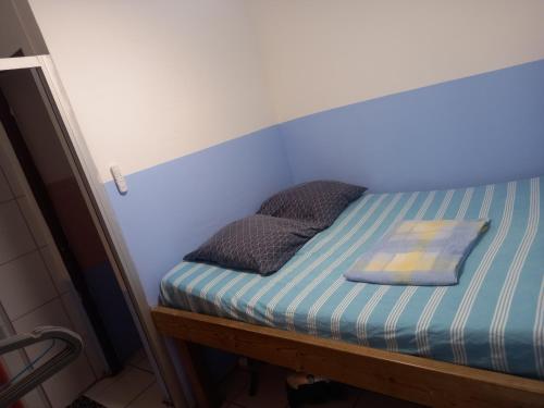 a small bed with two pillows on top of it at Niky house in Fort-de-France