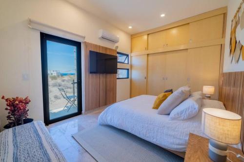 a bedroom with a large bed and a large window at Casa nueva a 3 min del Malecón! in La Paz