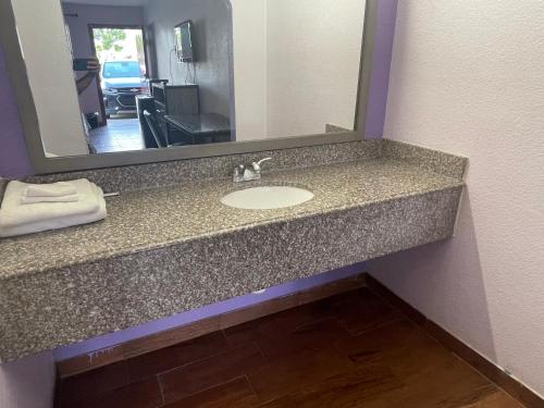 un bancone del bagno con lavandino e specchio di The village inn a Denham Springs