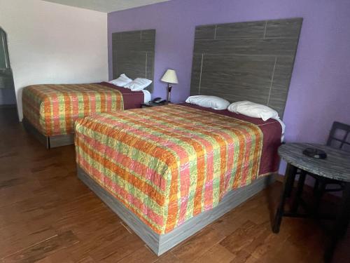 um quarto de hotel com duas camas e uma mesa em The village inn em Denham Springs