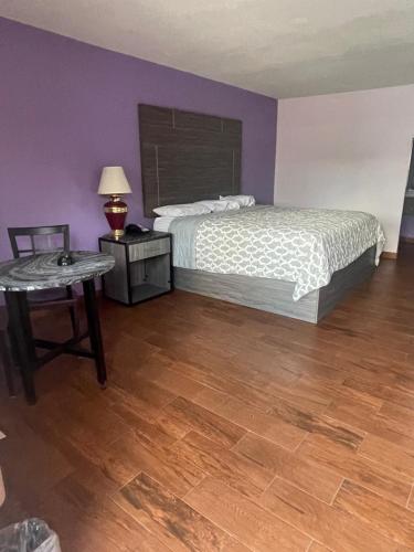 a bedroom with a bed and a table with a lamp at The village inn in Denham Springs